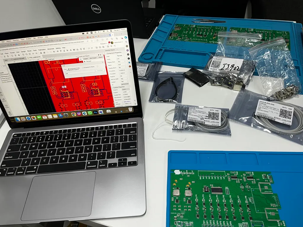 PCB design on a laptop beside components and controller boards