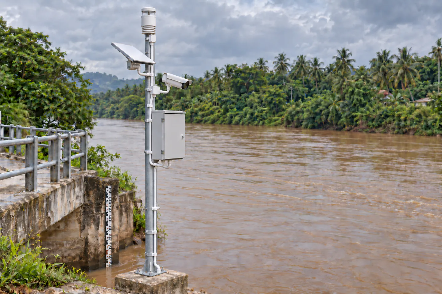 Supplied riverside monitoring setup image with weather sensor, camera, flat terminal and enclosed equipment cabinet on a pole